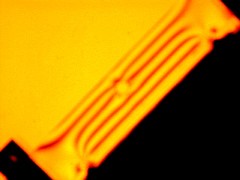 Photograph of an annealed bar with hole undergoing 4-point bending under polarised light