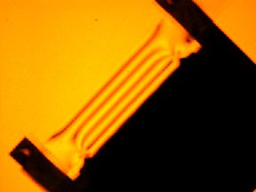 Photograph of an annealed bar undergoing 4-point bending under polarised light