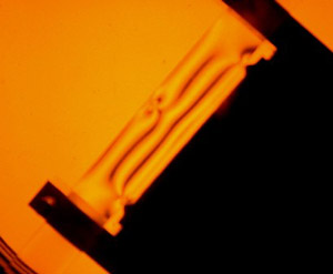 Photograph of an annealed and notched bar undergoing 4-point bending under polarised light
